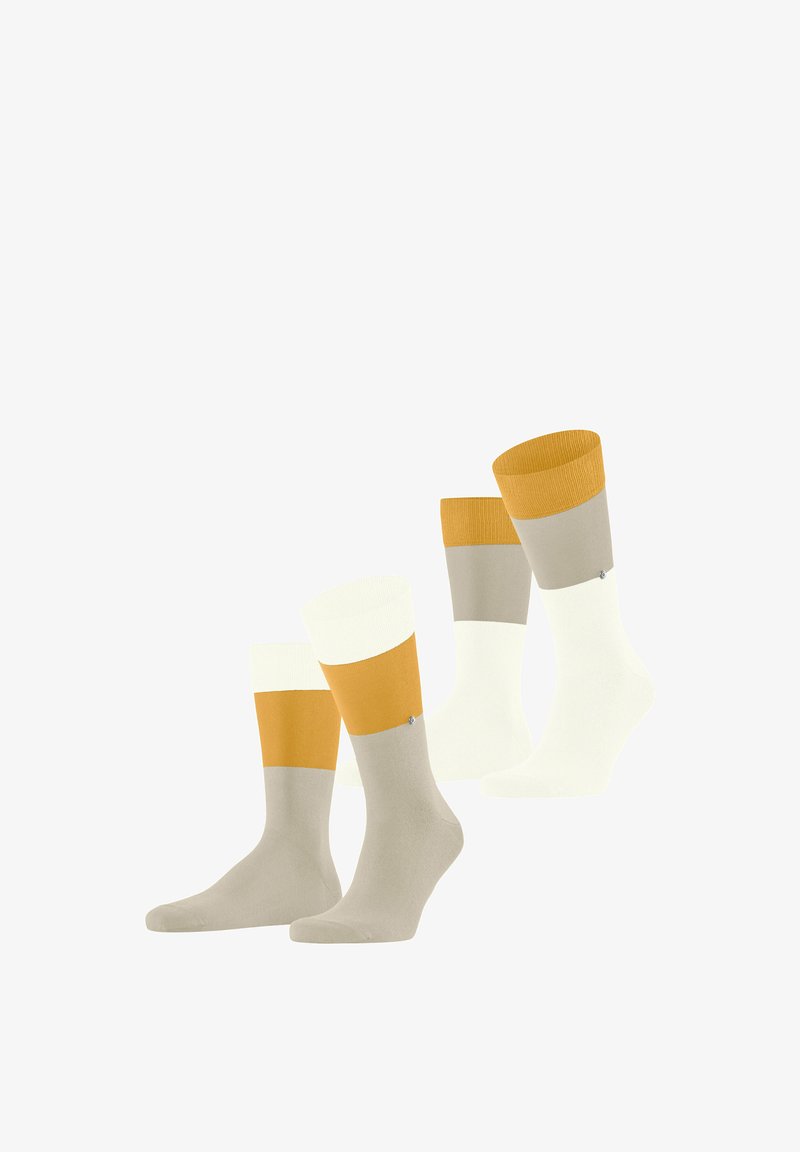 Dwie pary kolorowych skarpetek z podziałem na bloki kolorów: musztardowy, beżowy i biały, ustawione pionowo na białym tle.