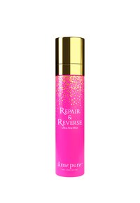 Rosa cylindrisk flaske med gyldne accenter, etiketteret "Repair & Reverse Ultra-fine Mist," med et prikket design mod toppen.