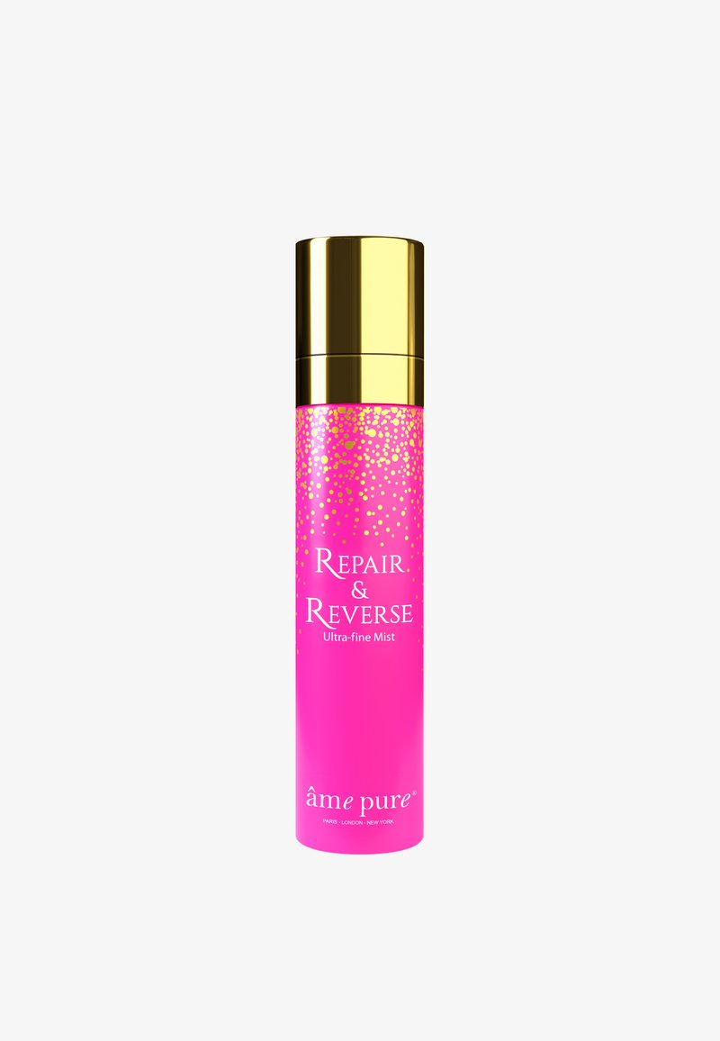 Rosa cylindrisk flaske med gyldne accenter, etiketteret "Repair & Reverse Ultra-fine Mist," med et prikket design mod toppen.