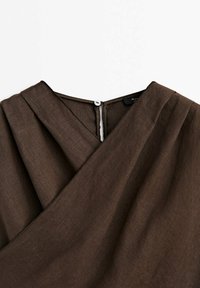Robe en lin marron avec un design enroulé, décolleté en V et fermeture à boutons dans le dos. Le tissu a une texture lisse et un léger éclat.