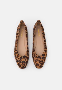 Pár baletních střevíčků s leopardím potiskem, špičaté špičky a béžové stélky, značka "ANNA FIELD" vytištěná zlatě uvnitř.