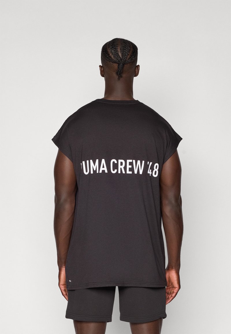 Black sleeveless shirt with a wide neckline, featuring "PUMA CREW '48" printed in white on the back. Fabric appears smooth and lightweight.