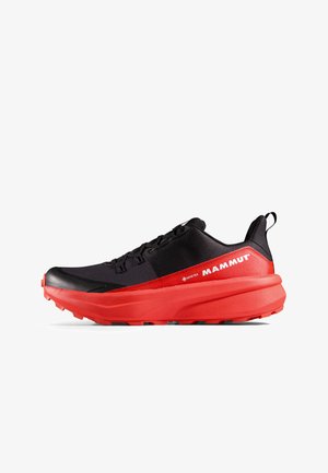 Czarne i czerwone buty do biegania w terenie z teksturowaną cholewką, grubą podeszwą amortyzującą oraz sznurówkami. Na boku znajduje się czerwone logo marki Mammut.