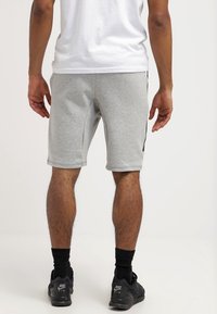 Gray cotton shorts with a fitted design, knee-length cut, and side pockets, featuring black accents along the sides.