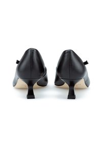 Zwarte leren hakken met een pointed design, kleine vierkante hakken en achterste lintaccenten. Gladde textuur en minimalistische stijl.