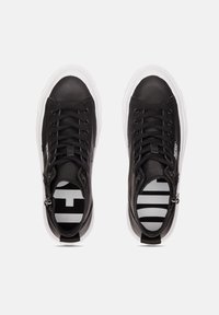 Mustat nahkaiset korkeavartiset tennarit valkoisilla kumipohjilla, nauhakuvaus ja raidallinen sisäkuvio. Sivuilla vetoketjut helppoa pääsyä varten.