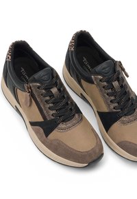 Paire de baskets marron et noires décontractées avec détail imprimé léopard, lacets noirs, fermeture éclair latérale et semelles beiges rembourrées sur fond blanc.