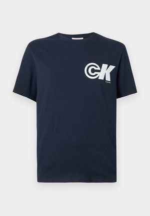 T-shirt en coton bleu marine avec un col rond, des manches courtes et un logo "CK" blanc imprimé sur le côté gauche de la poitrine.