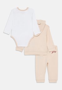 Il set di abbigliamento per bambini color beige chiaro include un body a maniche lunghe, una felpa con cappuccio e pantaloni della tuta, caratterizzati da una texture morbida e un logo ricamato.