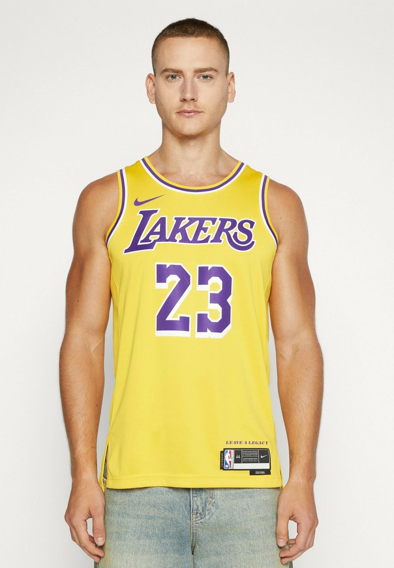 Maglia da basket gialla con la scritta "LAKERS" in viola, numero "23" in bianco e logo Nike. Tessuto a rete con spacchi laterali e etichetta NBA.