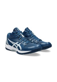 Chaussures de sport bleues avec une tige texturée, des accents blancs et un col rembourré. La semelle présente un motif de grip multidirectionnel.