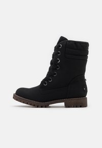 Bottines noires en matériau texturé, avec des œillets en métal, des lacets noirs, un col rembourré et une semelle robuste avec une base marron.