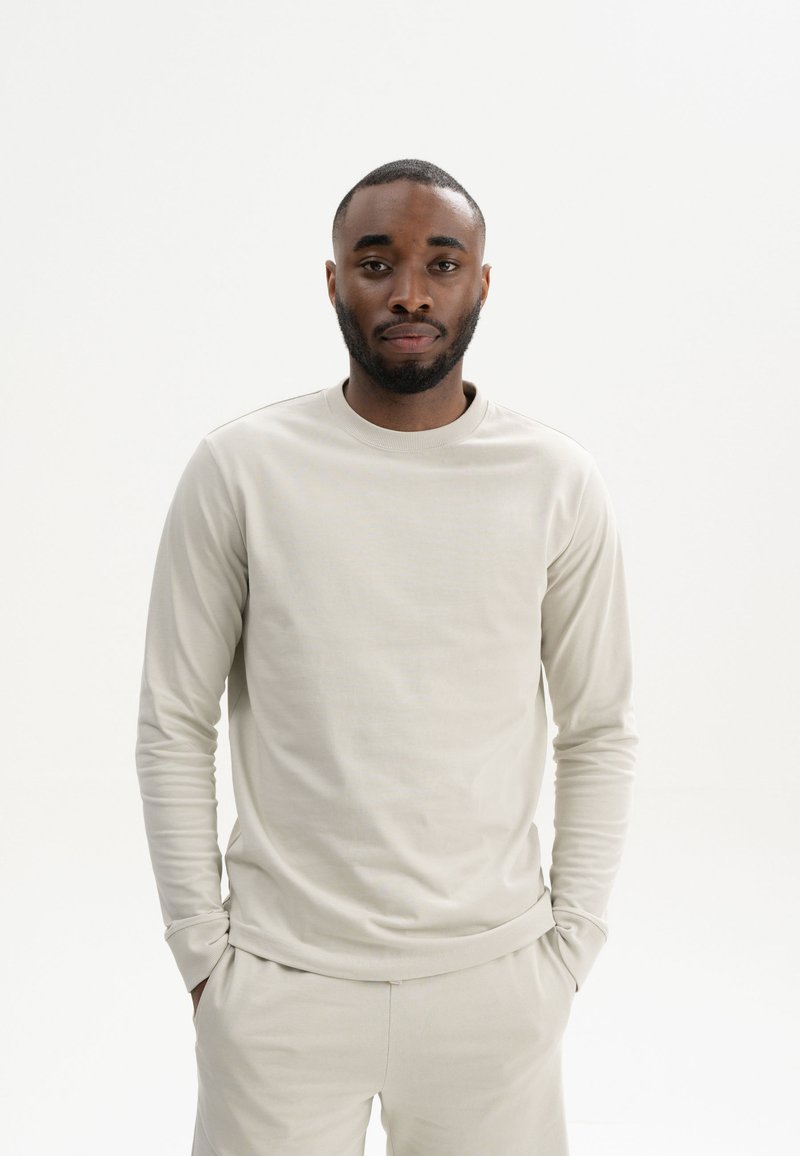 Hellgrauer Langarm-Crewneck-Pullover aus glattem Stoff, mit einfachem Design und lässiger Passform. Weiche Textur und minimale Nähte.