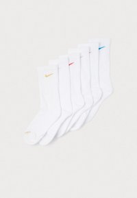 Nike-puuvillaclassesukat valkoisina, joissa on uurretekstuuri ja värisiä logoja (keltainen, punainen, sininen, harmaa) sukan yläosassa.