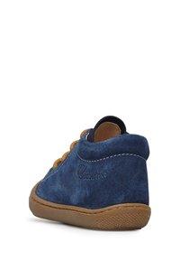 Zapato para niño pequeño en ante color navy con suela de goma marrón, cordones beige y costuras blancas. Punta redondeada y collar acolchado para mayor comodidad.