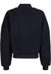 Zwarte, donzige trui van een textuur fleece materiaal, ruime pasvorm, hoge halslijn en geribbelde manchetten en zoom. Geen zichtbare sluitingen.