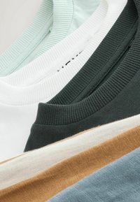 Viisi crewneck-t-paitaa pehmeästä puuvillasta: vaaleanvihreä, valkoinen, tumma vihreä, beige ja vaaleansininen, joissa on ribbireunat ja normaali istuvuus.