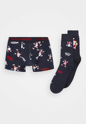 Des sous-vêtements navy et des chaussettes assorties arborent des motifs festifs de Santa et le texte "JOYEUX NOËL". Taille élastique avec la marque "JACK & JONES".