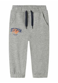 Grijze sweatpants met een elastische tailleband, marineblauwe trekkoorden, zijzakken en een 'STADIUM'-opdruk in blauw en oranje op het linkerbovenbeen.