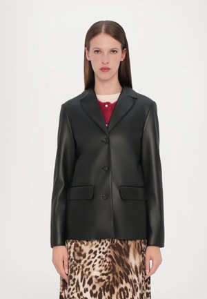 Črna umetna usnjena blazer jakna z izrezanim ovratnikom, dvema sprednjima žepoma in tremi gumbi. Nosi se čez krilo z leopardjim vzorcem. Gladka tekstura.