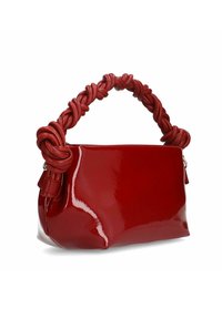 Red patent leather handbag with a knotted red handle, featuring a smooth, glossy texture and a rectangular shape. Zippered closure.