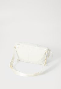 Biały torebka crossbody wykonana z miękkiego materiału. Posiada zamek błyskawiczny, regulowany pasek oraz subtelne przeszycia na zewnątrz.