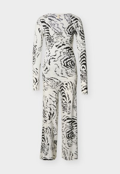 Σετ λευκό μακρυμάνικο τοπ και παντελόνι με μαύρο μοτίβο προσώπου τίγρης και ρίγες, με V-λαιμόκοψη και παντελόνια φαρδιάς γραμμής.