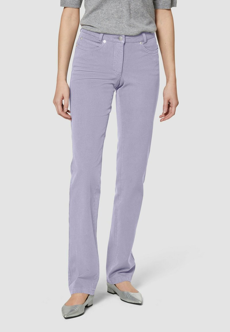 Licht paarse jeans met een aansluitend ontwerp, vijf-pocket stijl en zilveren accenten, gecombineerd met een grijze top en zilveren ballerina's.