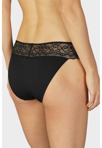 Mutande hipster nere con una cintura in pizzo dai bordi scallop e intricati motivi a spirale. Tessuto morbido con un design senza cuciture.