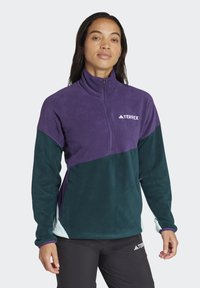 Fleece pulloverjack met een kwart-rits kraag, paarse en teal kleurblokken, met een logo op de borst. Zachte textuur, lange mouwen.