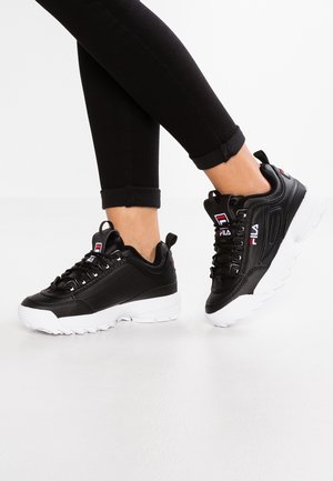 Black Fila sneakers with leather upper, white rubber sole, and lace closure. Notable red and blue logo detail on the sides.
