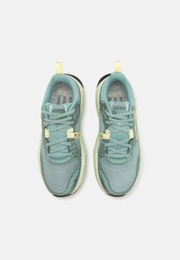 Light blue athletic shoes with mesh upper, textured accents, and yellow pulls. Features a cushioned sole and laces for a secure fit.