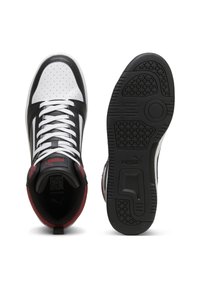 Hoge sneakers met een bovenwerk van wit en zwart leer, geperforeerde neus, rode accenten en een zwarte rubberen zool met een gestructureerde grip.