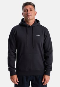 Black hooded sweatshirt made of soft fabric, featuring a front kangaroo pocket, drawstrings, and a small embroidered logo on the chest.