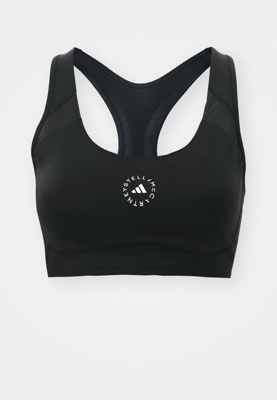 Sostén deportivo negro con un diseño de espalda nadadora, hecho de un tejido suave. Cuenta con un logotipo circular blanco en el centro y acentos de malla.