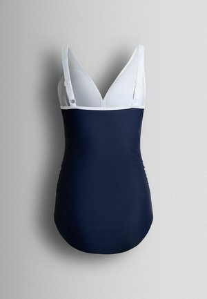 Navy blue one-piece swimsuit with white adjustable straps and deep V neckline, displayed against a gray background.