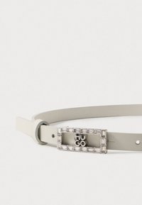 Cinturón de cuero gris claro con una hebilla metálica rectangular adornada con un borde de cristal y el nombre de la marca "HUGO" en el centro.