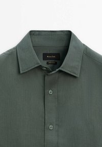 Donkergroene overhemd met korte mouwen, voorzien van een klassieke kraag, knopenlijst en zachte stoftextuur. Label zegt "Massimo Dutti."