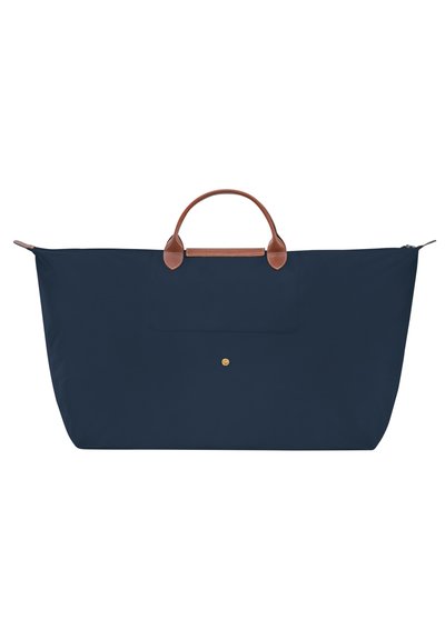 Navy blue tote bag made of durable fabric, featuring brown leather handles and a front pocket. Zippered closure with a gold logo accent.