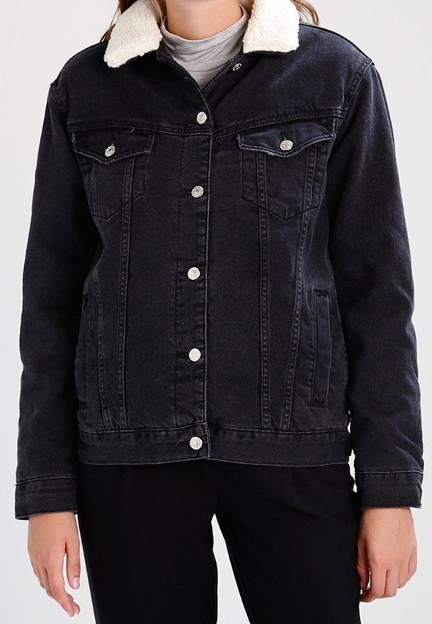 Svart denimjacka med fårskinnskrage, tryckknappar, två bröstfickor och en strukturerad passform; har en mjuk yta och en avslappnad design.