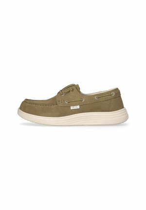 Scarpa da barca in suede marrone con profilo basso, suola in gomma crema, dettagli in pizzo e occhielli in metallo per la chiusura.
