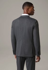 Szary żakiet w marynarskim stylu z teksturowanej tkaniny, o slim fit, z klapami z wcięciem i mankietami zapinanymi na trzy guziki. Dopasowany design z wentylowanym tyłem.