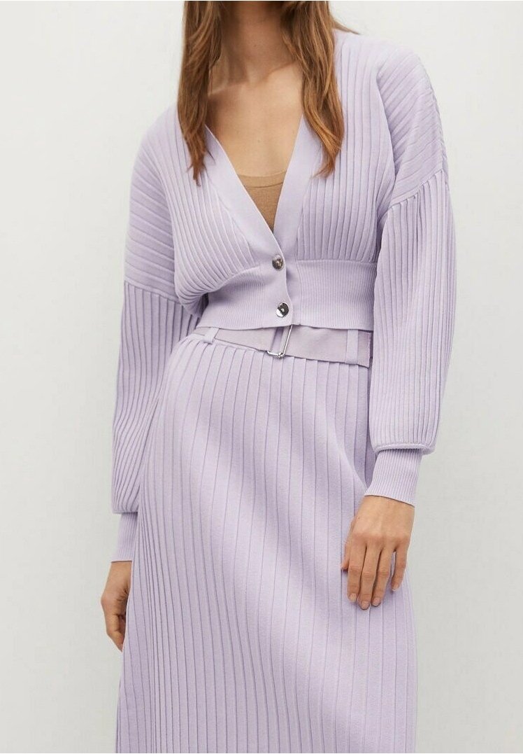 Cardigan côtelé lilas avec un col en V profond, manches longues et deux boutons argentés ; porté par-dessus une robe ajustée, avec une ceinture en accent.