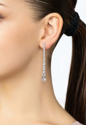 Orecchini pendenti in tonalità argento con numerosi piccoli cristalli trasparenti, attaccati a un cristallo più grande alla fine, caratterizzati da un design lineare.