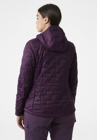 Fialová izolační bunda s kapucí, která má prošívanou texturu a přiléhavý střih. Na zádech se nacházejí vertikální švy a hladký povrch.