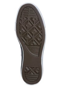 Suela de una zapatilla Converse All Star mostrando una banda de rodadura de goma marrón con patrones geométricos y un borde lateral blanco.