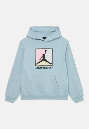 Világoskék kapucnis pulóver, elülső kenguruzsebbal, amelyen egy multi színű Jordan logó található, rajta egy kosárlabdázó sziluettjével és az alatta lévő "JORDAN" felirattal.