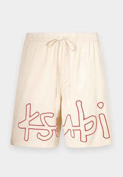 Beige shorts met een elastische tailleband en koord. Bevat een textuurpatroon en een rood "ksubi" logo aan de linkerkant.