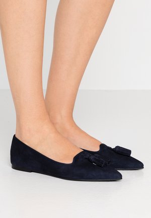 Navy-gestreifte Wildlederflats mit spitz zulaufendem Design, verziert mit einer dekorativen Quastenakzent an der Vorderseite und einer glatten Gummisohle.