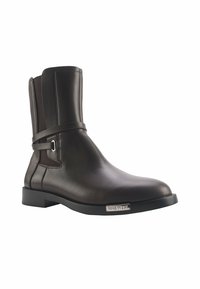 Braune Leder-Ankle Boots mit glatter Textur, elastischem seitlichem Einsatz und einem Riemen-Detail. Sie verfügen über eine quadratische Zehenpartie und einen niedrigen Blockabsatz.